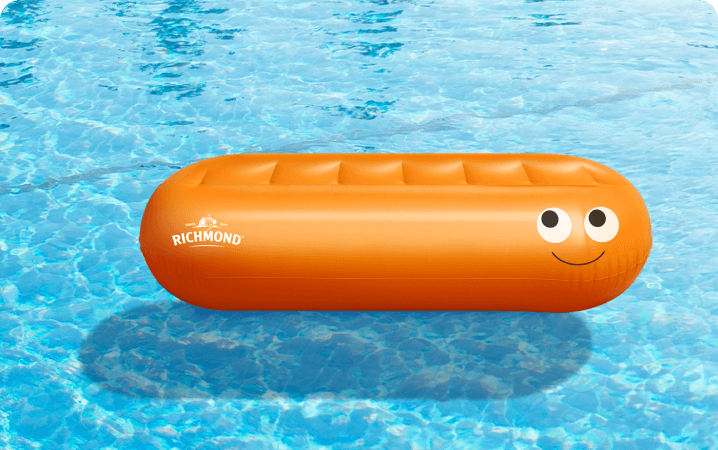 A Richmond-branded sausage-shaped inflatable lilo floating in a swimming pool, one of the 250 available prizes.